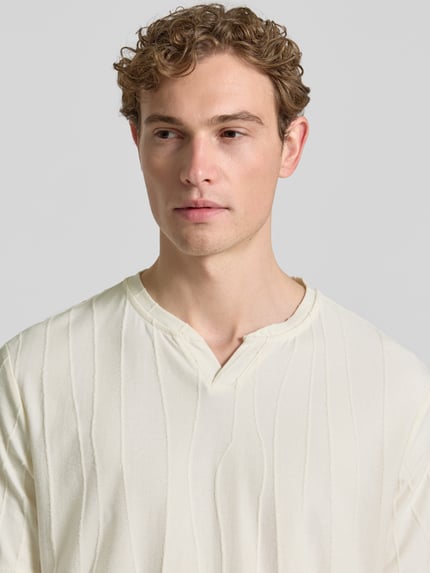 Männermodel trägt T-Shirt mit Strukturmuster und V-Ausschnitt von Antony Morato in Offwhite, Baumwoll-Mix, Regular Fit, Nahaufnahme Oberkörper.