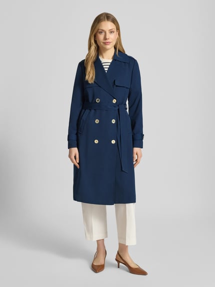 Frauenmodel trägt Zweireihiger Trenchcoat mit Bindegürtel von MICHAEL Michael Kors in Dunkelblau, Regular-Fit, Reverskragen, Rückenlänge 47 cm, Schulterbreite 40 cm, Brustweite 50 cm, Ärmellänge 63 cm, Ganzkörperansicht von vorne.