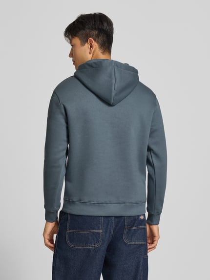 Männermodel trägt Regular Fit Hoodie aus Baumwoll-Mix mit Logo-Print von Alpha Industries in Blau, Rückenansicht, Kontext Herren Hoodie.