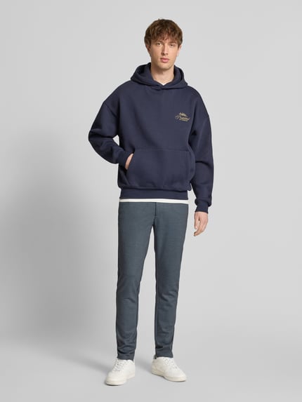 Männermodel trägt Slim Fit Chino aus Viskose-Mix Modell 'MARK' von Only & Sons, unifarben, Melange, Ganzkörperansicht von vorne.
