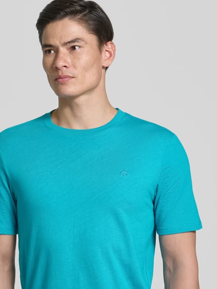 Mannelijk model draagt Regular Fit T-Shirt met Logo-Stitching van Scotch & Soda in turquoise, katoen, ronde hals, detailopname bovenlichaam.