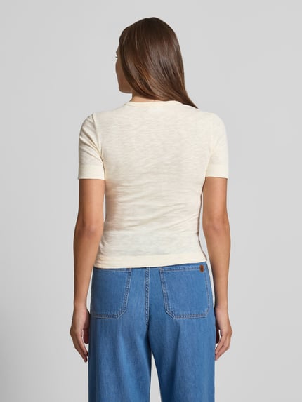 Frauenmodel trägt T-Shirt mit Rundhalsausschnitt und Knopfleiste von Jake*s Casual, reine Baumwolle, Slim Fit, helle Farbe, Ganzkörperansicht Rückansicht.