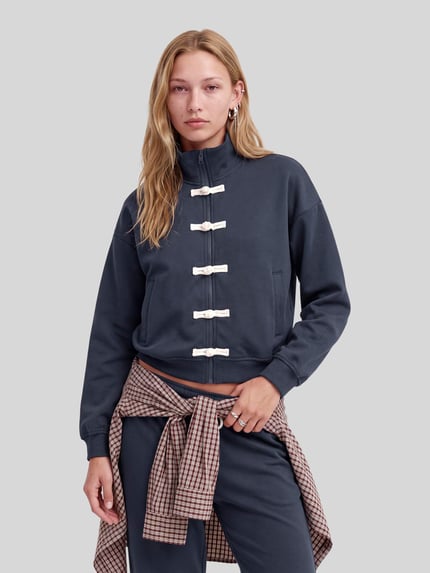Frauenmodel trägt Sweatjacke mit Stehkragen Modell 'LEONA' von JJXX, dunkelblau, Baumwoll-Mix, Zweiwege-Reißverschluss, Eingrifftaschen, Regular Fit, Ganzkörperansicht von vorne.