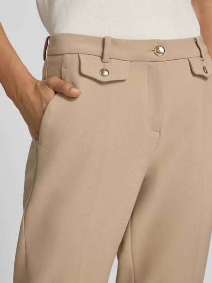 Kobiece model prezentuje spodnie Schmale Hose mit Viskose-Baumwoll-Anteil Modell 'KRYSTAL' od CAMBIO, beżowy kolor, gładka faktura, zbliżenie na górną część nogawek, Damen Schmale Hose von CAMBIO, detaliczne ujęcie.