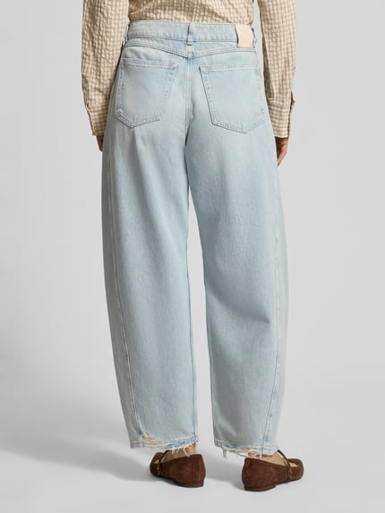 Frauenmodel trägt Relaxed Fit Barrel Jeans aus reiner Baumwolle Modell 'BALOON HR 1.0' von BOSS Orange in blauer Denim-Optik, Gesäßtaschen, Ganzkörperansicht Rückansicht.