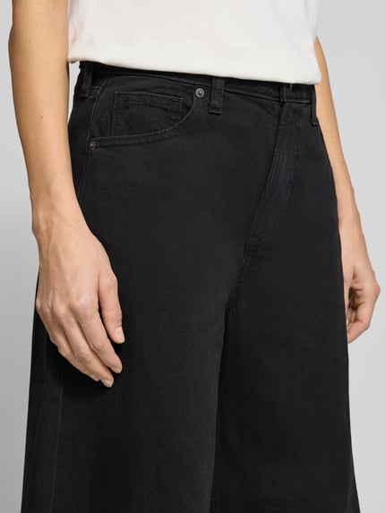 Frauenmodel trägt Barrel Jeans mit Eingrifftaschen Modell 'HORSESHOE' von GAP, aus Baumwoll-Lyocell-Mix in Schwarz, Nahaufnahme Oberkörper.