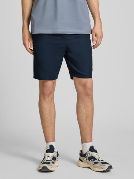 Männermodel trägt Regular Fit Bermudas aus Baumwoll-Leinen-Mix Modell 'LINUS' von Only & Sons in Dunkelblau, unifarben, Ganzkörperansicht von vorne.