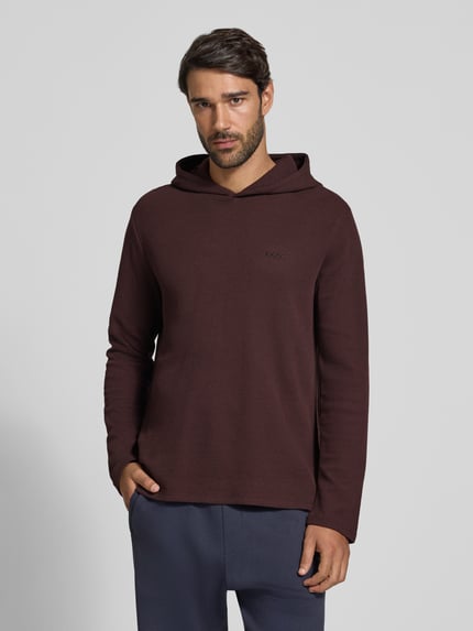 Männermodel trägt Relaxed Fit Sweatshirt aus Baumwoll-Mix Modell 'Waffle LS' von BOSS in Dunkelrot, strukturierte Oberfläche, Nahaufnahme Oberkörper, Herren Hoodie von BOSS.