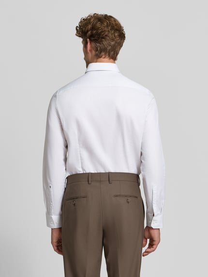 Männermodel trägt weißes Slim Fit Businesshemd aus reiner Baumwolle Modell 'New Kent' von Seidensticker, Herren Businesshemd, Ganzkörperansicht Rückansicht.