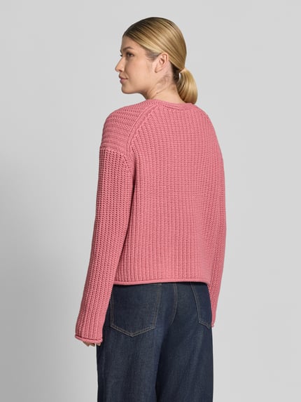 Frauenmodel trägt Loose Fit Pullover aus Baumwoll-Mix von Marc O'Polo in Rosa, grob gestrickt, kombiniert mit Jeans, Ganzkörperansicht Rückansicht. Damen Pullover von Marc O'Polo.