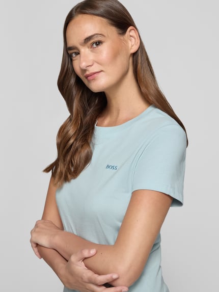 Vrouwenmodel draagt Regular Fit T-shirt uit zuivere katoen model 'C_ESOGO_1' van BOSS Orange; lichtblauw, glad oppervlak. Nahaufnahme bovenlichaam.
