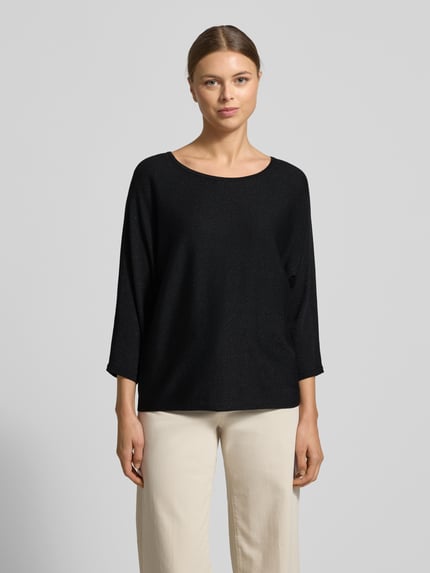 Frauenmodel trägt Relaxed Fit Pullover aus Viskose-Mix in Strick-Optik von comma, U-Boot-Ausschnitt, 3/4-Arm, Glitzer-Optik, Ganzkörperansicht von vorne.