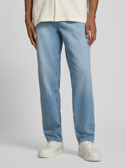 Männermodel trägt Straight Fit Jeans im 5-Pocket-Design Modell 'Ryder' von Les Deux in Hellblau, reine Baumwolle, Vorderansicht Oberkörper bis Schuhe.