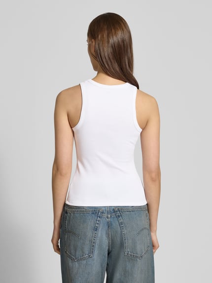 Frauenmodel trägt Tanktop in Ripp-Optik von REVIEW aus Baumwoll-Elasthan-Mix, eng anliegende Passform, Rückansicht, Ganzkörperansicht.