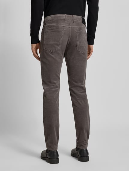 Männermodel trägt Modern Fit Stoffhose mit 5-Pocket-Design von Bugatti, Baumwoll-Elasthan-Mix, grauer Farbton, Ganzkörperansicht Rückansicht.