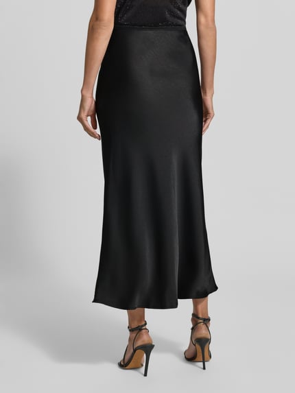 Frauenmodel trägt Maxirock aus Satin Modell 'Vicky' von Neo Noir in Schwarz mit elastischem Bund, körpernahe Passform, Ganzkörperansicht Rückansicht.