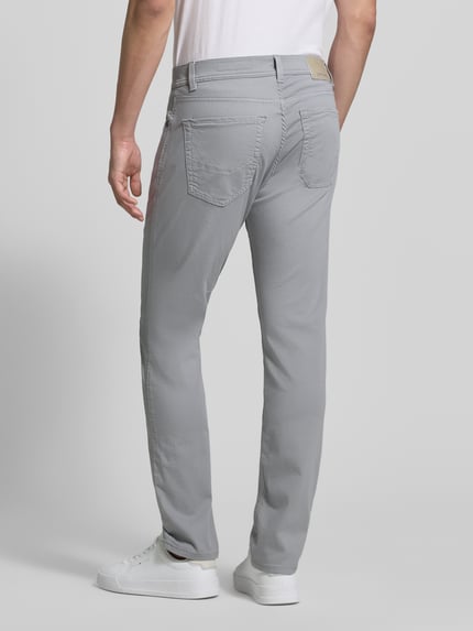 Mannenmodel draagt grijze jeans met labeldetail model 'Lyon' van Pierre Cardin, katoenmix met stretch, steekzakken, regular fit, bandwijdte maat 32/32: 41 cm, binnenbeenlengte 80 cm, volledig lichaam achteraanzicht.