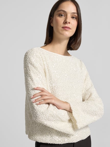 Frauenmodel trägt Pullover mit Allover-Paillettenstruktur von S. OLIVER BLACK LABEL, cremefarbene Struktur, U-Boot-Ausschnitt, Nahaufnahme Oberkörper