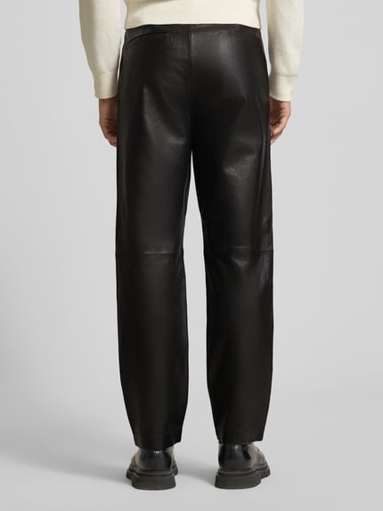 Männermodel trägt Wide Leg Hose aus echtem Lammleder Modell 'CHANCE' von SELECTED HOMME, Glattleder, glänzend, Ganzkörperansicht Rückansicht.