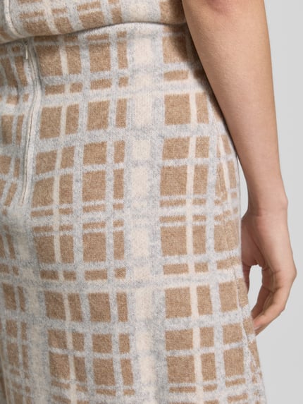 Frauenmodel trägt Knielanger Rock aus reiner Wolle von Christian Berg Woman, beige-graues Karomuster, A-Linie, Nahaufnahme Oberkörper, Reißverschluss, Bundweite 39 cm, Gesamtlänge 54 cm.