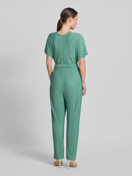 Vrouwenmodel draagt Jumpsuit met plissévouwen en strikceintuur model 'Pe44arl' van ZABAIONE in groen, getailleerd model, totale lengte 145 cm, ruglengte 38 cm, borstwijdte 39 cm, binnenbeenlengte 69 cm, wikkellook, V-hals, plissévouwen, strikceintuur, all-over look, driekwartmouwen, elegante textuur, achteraanzicht volledige lichaamsopname.