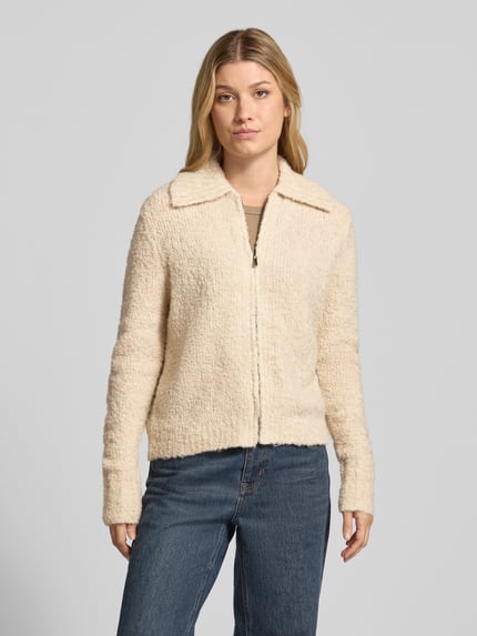 Vrouwenmodel draagt Regular Fit gebreid jack met platte kraag en ritssluiting van zero, beige kleur, dames, ruglengte maat 36: 56 cm, mouwlengte maat 36: 66 cm, geheelopname van voren.