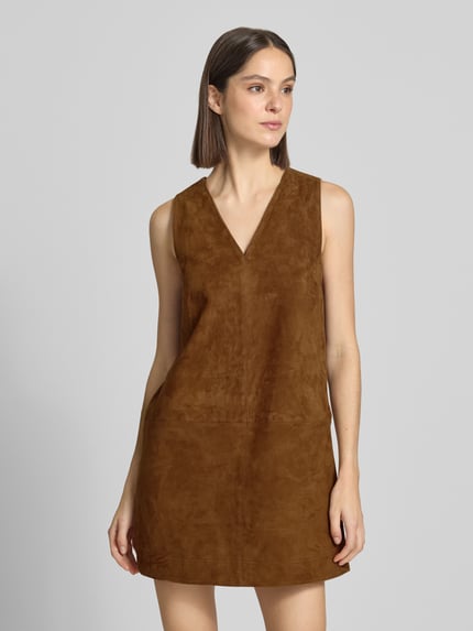 Frauenmodel trägt Minikleid aus Leder mit V-Ausschnitt von Stefanel in Braun mit geradem Schnitt und Teilungsnähten, Nahaufnahme Oberkörper.