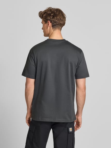 Männermodel trägt Relaxed Fit T-Shirt aus reiner Baumwolle Modell 'FRED LIFE' von Only & Sons, Optik: Unifarben, Ganzkörperansicht Rückansicht.