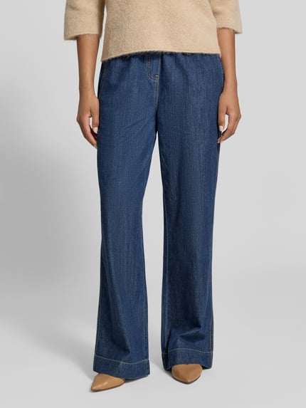 Frauenmodel trägt Wide Leg Jeans aus reiner Baumwolle von Juvia in Dunkelblau mit elastischem Bund, Tunnelzug und Eingrifftaschen, Nahaufnahme Oberkörper.