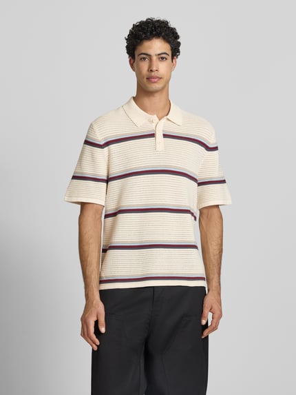 Männermodel trägt regular fit heren poloshirt van puur katoen met streepmotief, model 'MAINE' van Jack & Jones, knoopsluiting, ruglengte maat M 70 cm, Ganzkörperansicht von vorne.