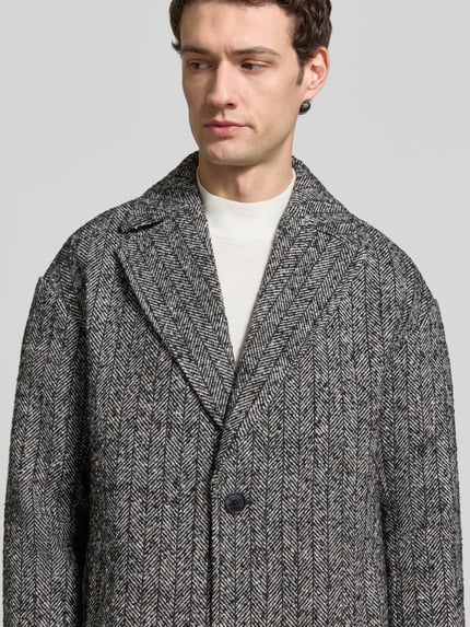 Männermodel trägt Mantel mit Reverskragen Modell 'Lancasters' von Matinique, schwarz-grau gemustert, material-mix met wol, knopsluiting, regular fit, Nahaufnahme Oberkörper