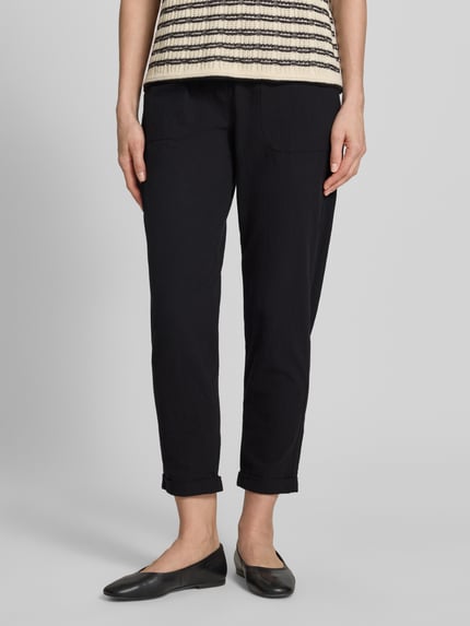 Frauenmodel trägt Hose mit elastischem Bund und Tunnelzug Modell 'Cissie' von Soyaconcept in Schwarz, Reine Baumwolle, Relaxed-Fit, Nahaufnahme Unterkörper.