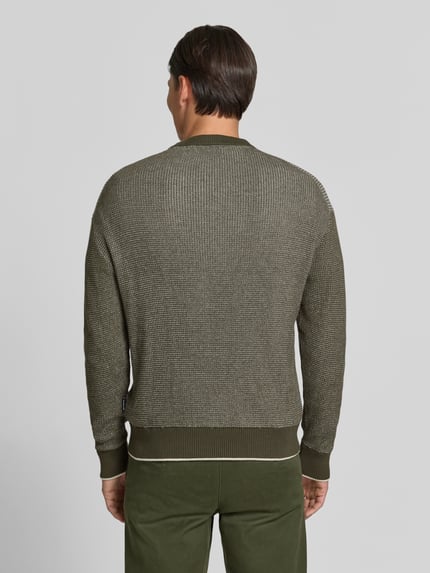 Männermodel trägt Regular Fit Strickpullover aus reiner Baumwolle von HECHTER PARIS in Olivgrün, Strukturstrick, Ganzkörperansicht Rückansicht. Rückenlänge 63 cm, Ärmellänge 61 cm, elastische Abschlüsse, Rundhalsausschnitt.