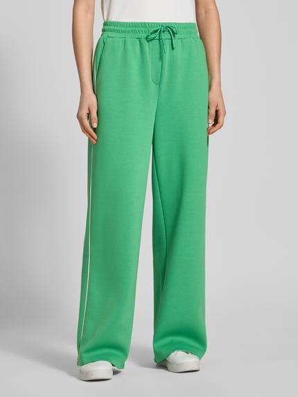 Vrouwenmodel draagt Wide fit sweatpants met elastische band model 'KATE NEO' van ICHI, materiaalmix met viscose, tunnelkoord, groene kleur, binnenbeenlengte maat S 76 cm, bandwijdte 37 cm, volledige lichaamsvoorzijde.