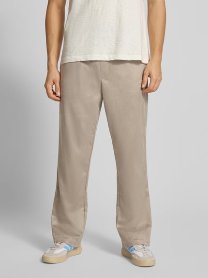 Mannelijk model draagt Stoffhose mit elastischem Bund van Pegador in beige met losse pasvorm, Franse steekzakken, vooraanzicht heup-close-up.