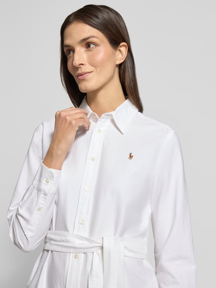 Vrouwenmodel draagt Midikleid mit Knopfleiste van Polo Ralph Lauren, witte katoen, getailleerd, hemdkraag, knopen, tailleriem, Nahaufnahme bovenlichaam.