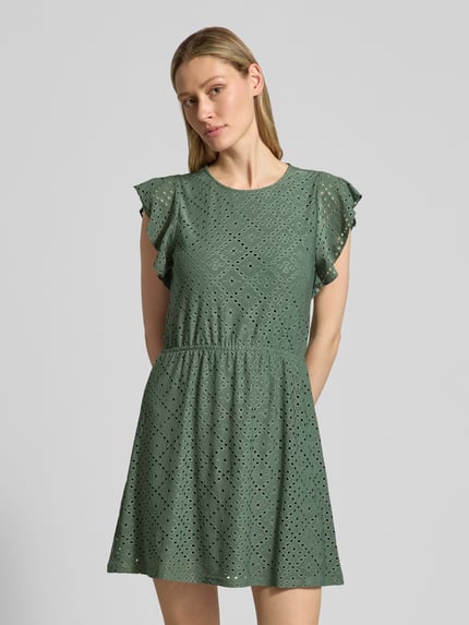 Vrouwenmodel draagt Tailliertes Sommerkleid mit Lochstickmuster Modell 'TASSA' van Vero Moda, effen kleuren, getailleerd, minilengte, ronde hals, jurk met korte mouwen, elastische tailleband, ajourpatroon, Ganzkörperansicht van voren.