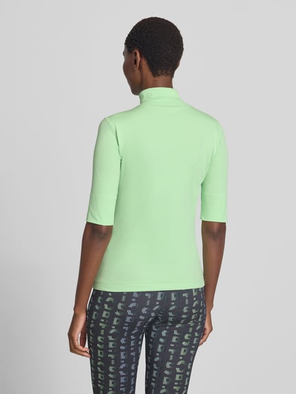 Männermodel trägt zielony damski t-shirt Slim Fit T-Shirt aus Baumwoll-Mix mit Stehkragen von Marc Cain, mieszanka bawełny, krój slim fit, stójka, rękaw o dł. 1/2, Długość tyłu w rozmiarze 36: 54 cm, Ganzkörperansicht Rückansicht