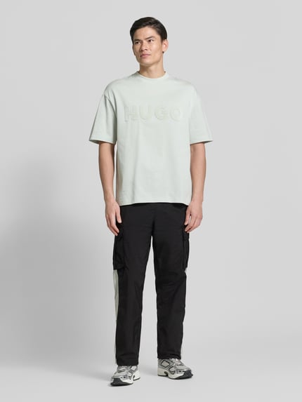 Männermodel trägt Regular Fit Cargohose mit Label-Applikation Modell 'COLAS262' von HUGO in Two-Tone-Optik, Twill, Ganzkörperansicht von vorne