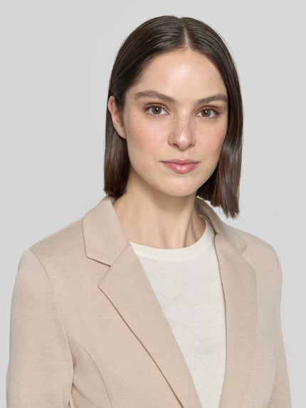 Frauenmodel trägt Slim Fit Blazer mit Paspeltaschen Modell 'KATE PIQUE' von ICHI aus Baumwoll-Mix, Nahaufnahme Oberkörper.