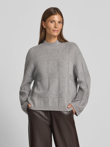 Frauenmodel trägt Oversized Wollpullover mit Kaschmir-Anteil von Emporio Armani in Grau mit Strukturmuster, Stehkragen, gerippten Abschlüssen, Nahaufnahme Oberkörper.