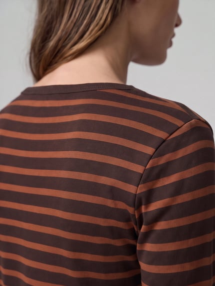 Frauenmodel trägt Pullover mit Rollsaum-Abschlüssen von S.OLIVER CASUAL, braun rostrot gestreift, Jersey-Textur, Nahaufnahme Oberkörper.