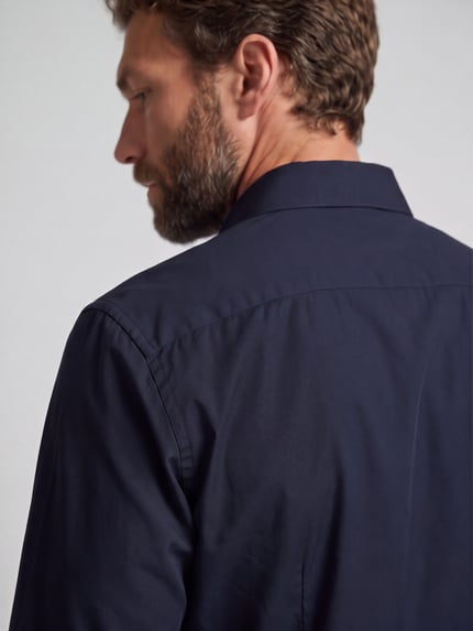 Männermodel trägt Regular Fit Businesshemd aus reiner Baumwolle von OLYMP in Dunkelblau mit glatter Textur, Nahaufnahme Oberkörper. Herren Businesshemd von OLYMP.