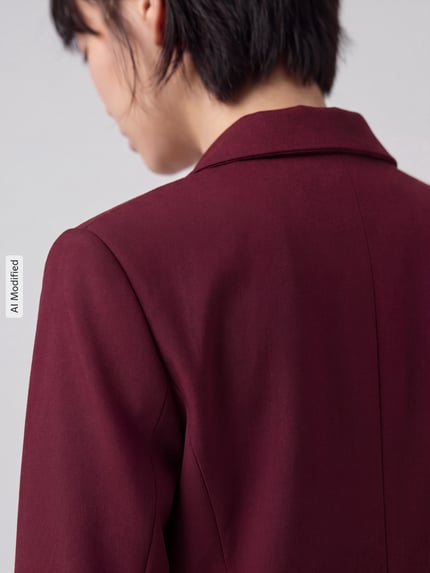 Frauenmodel trägt Regular Fit Longblazer aus Viskose-Mix Modell 'RITA' von Selected, bordeauxrot, glatte Textur, Nahaufnahme Rückansicht, KI-modifiziertes Bild.