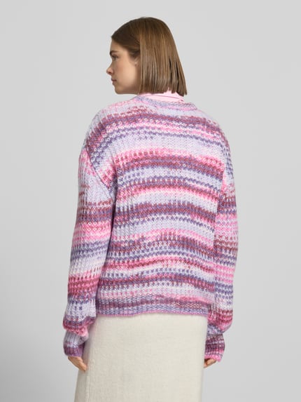 Vrouwenmodel draagt Regular fit pullover in breilook model 'Simone' van JJXX in roze, paars en wit met ronde hals, rugaanzicht.