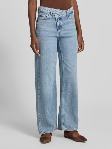 Kobieta nosi Wide Fit Jeans mit Leinen-Anteil Modell 'FIA' von Marc O'Polo, stylizowana na denim, krój wide fit, średni stan, zapięcie x-front, 5 kieszeni, mieszanka lnu, jasnoniebieski materiał o delikatnej fakturze, Ganzkörperansicht z przodu.