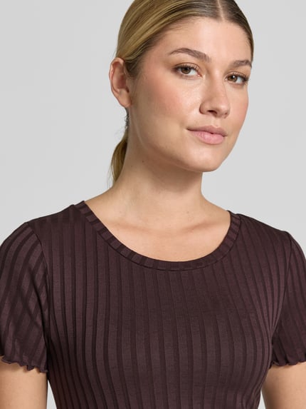 Frauenmodel trägt Slim Fit T-Shirt aus Viskose-Mix von Rich & Royal in Braun mit Kräuselsäumen, Rundhalsausschnitt, Nahaufnahme Oberkörper.