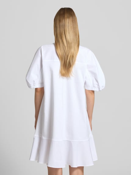 Frauenmodel trägt knielanges Tunika-Kleid mit Puffärmeln Modell 'ONORE' von MM by Max Mara aus Baumwoll-Mix mit Stretch-Anteil, A-Linie, Rückansicht Ganzkörperansicht.