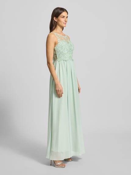 Frauenmodel trägt Regular Fit Abendkleid mit floralem Spitzenbesatz von Laona, semitransparentes Design in Mint mit Ziersteinbesatz, Ganzkörperansicht von vorne.