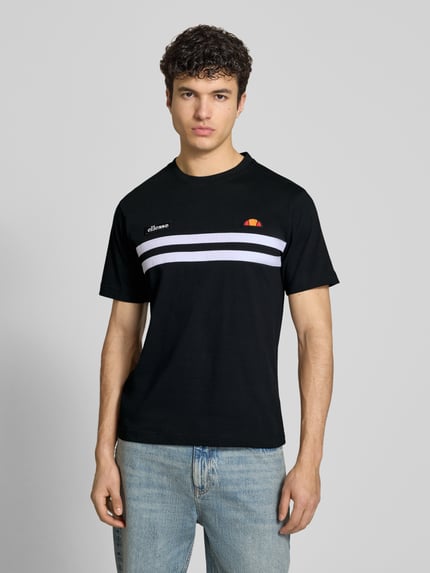 Męski model nosi T-Shirt mit Label-Stitchings Modell 'VENIRE' od Ellesse, czarny kolor, bawełna, krój regular fit, przód, ujęcie całej sylwetki.